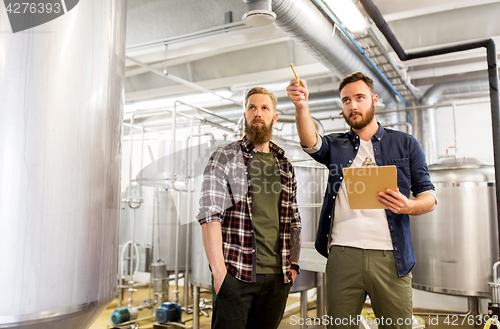 Image of men with clipboard at craft brewery or beer plant