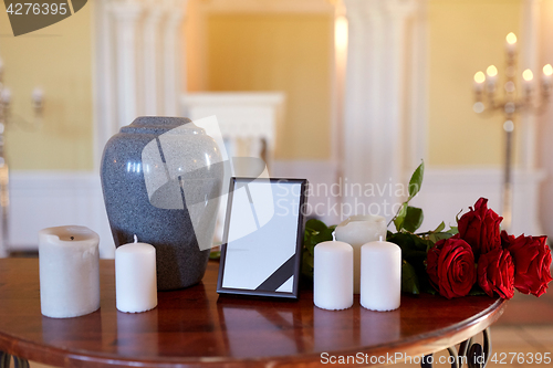 Image of photo frame, cremation urn and candles in church