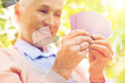 Image of close up of happy senior woman playing cards