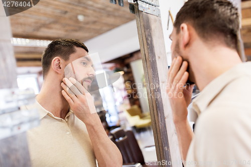 Image of man looking at himself at barbershop mirror