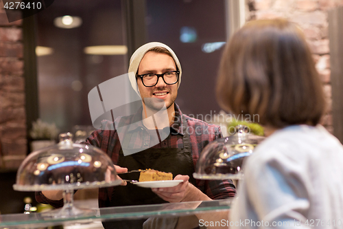 Image of man or barman with cakes serving customer at cafe