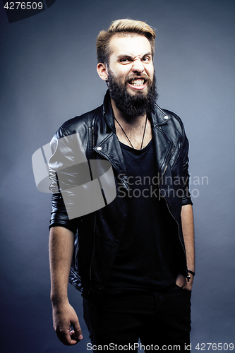 Image of portrait of young bearded hipster guy smiling on gray dark background close up, brutal modern man, lifestyle people concept