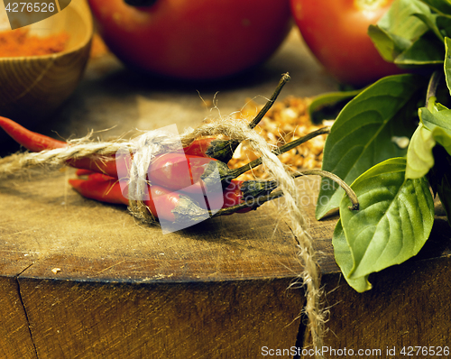 Image of vegetables on wooden kitchen with spicies, tomato, chilli, green