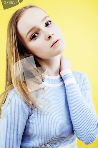 Image of lifestyle people concept: pretty young school teenage girl having fun happy smiling on yellow background