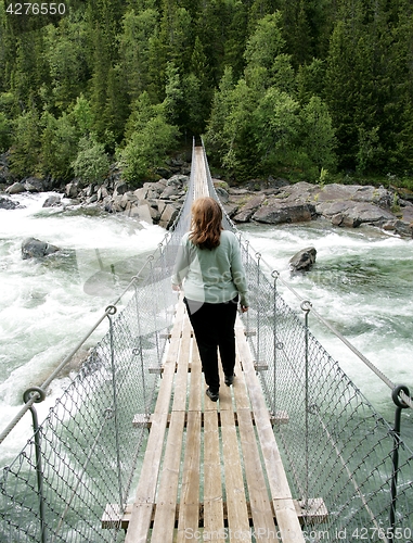 Image of Woman on suspension bridge