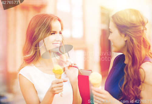 Image of woman with shopping bags and ice cream in city