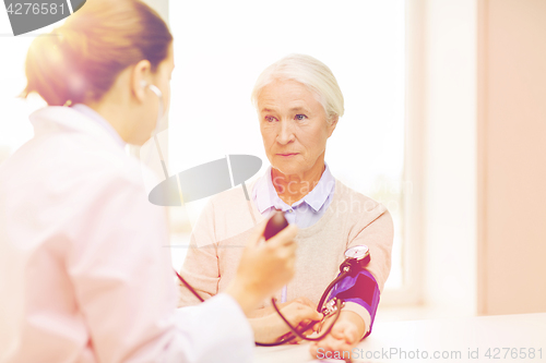 Image of doctor with tonometer and senior woman at hospital