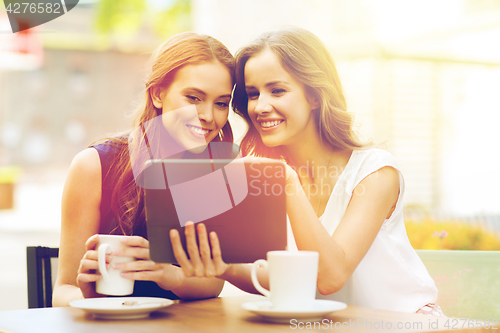 Image of young women with tablet pc and coffee at cafe