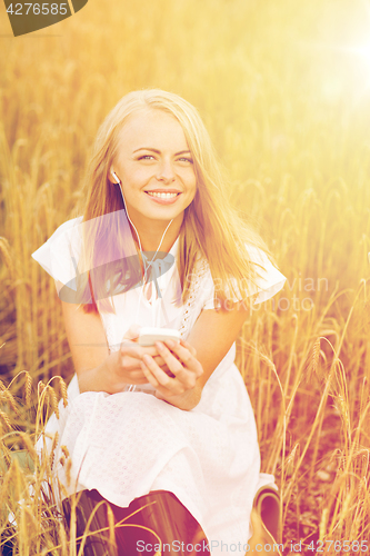 Image of happy woman with smartphone and earphones