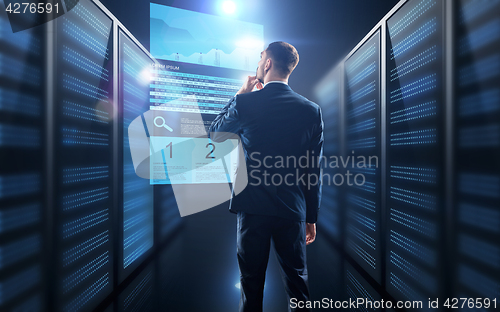 Image of businessman with charts on virtual screen