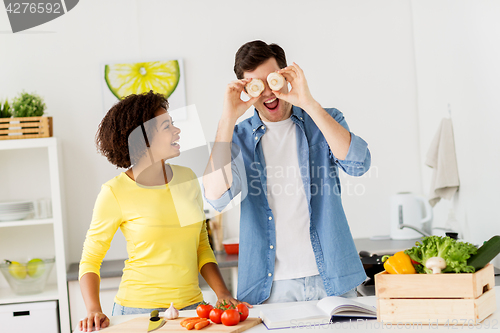 Image of happy couple cooking food and having fun at home