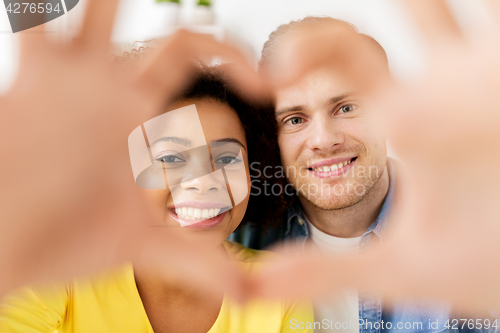 Image of happy couple looking through heart shape