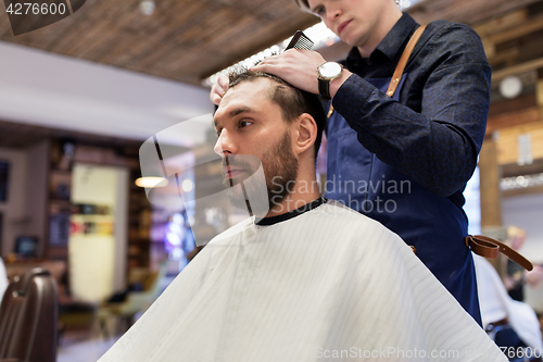 Image of man and barber cutting hair at barbershop