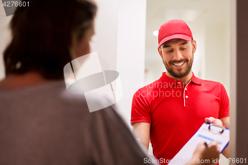 Image of deliveryman with clipboard at customer home