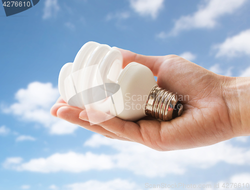 Image of close up of hand holding energy saving lightbulb