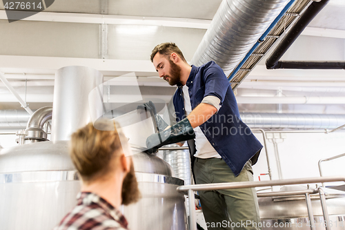 Image of men working at craft brewery or beer plant