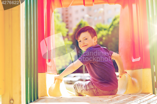 Image of happy little boy on slide at children playground