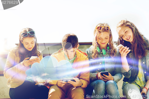 Image of happy teenage friends with smartphones outdoors