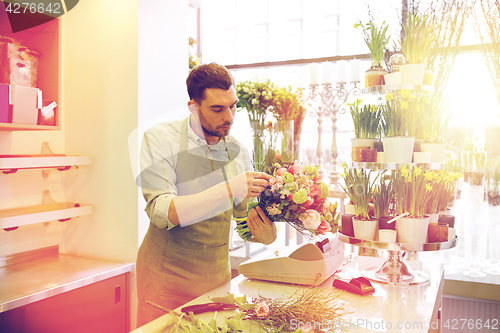 Image of florist man making bunch at flower shop