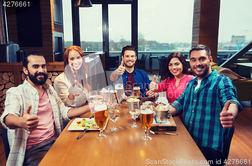 Image of friends dining and drinking beer at restaurant