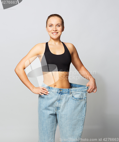 Image of young slim sporty woman in oversize pants