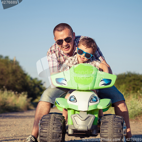 Image of Father and son playing on the road at the day time.