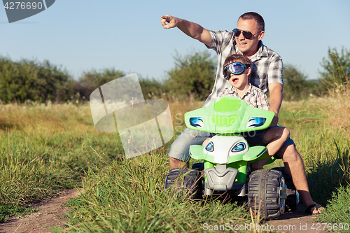 Image of Father and son playing on the road at the day time.