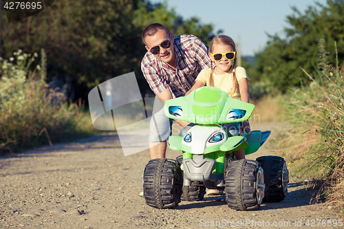 Image of Father and daughter playing on the road at the day time.