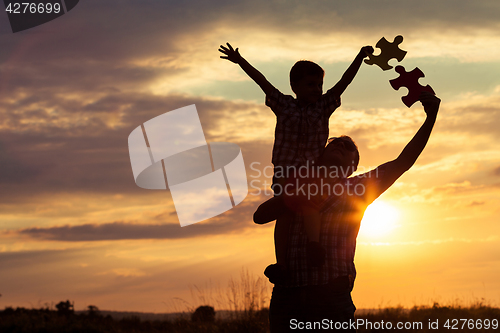 Image of Father and son playing at the park at the sunset time. 