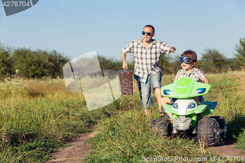 Image of Father and son playing on the road at the day time.