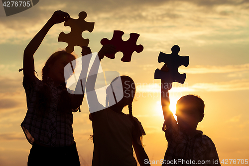 Image of Silhouette of happy people which playing on the beach at the sun