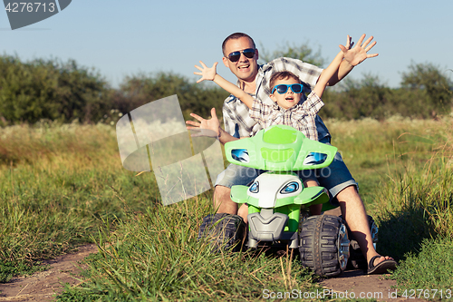 Image of Father and son playing on the road at the day time.