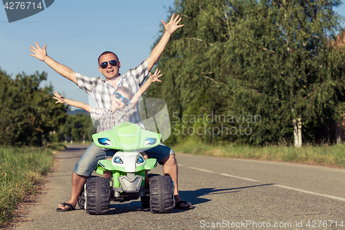 Image of Father and son playing on the road at the day time.