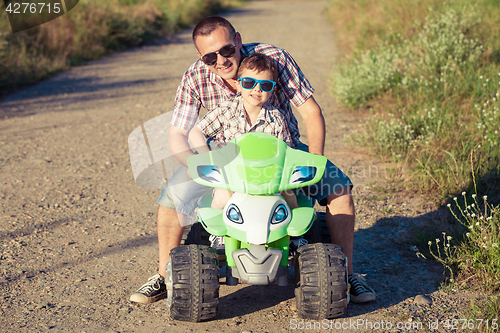 Image of Father and son playing on the road at the day time. 