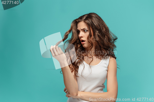 Image of Frustrated young woman having a bad hair on blue