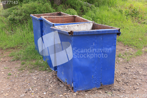 Image of Three empty garbage cans on the green grass