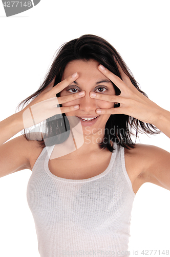 Image of Young woman looking through her fingers.