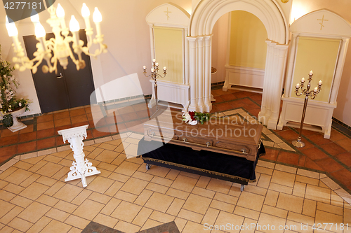 Image of coffin with flowers and stand at funeral in church