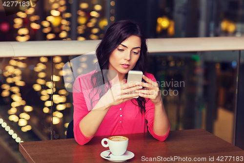 Image of woman with smartphone and coffee at restaurant