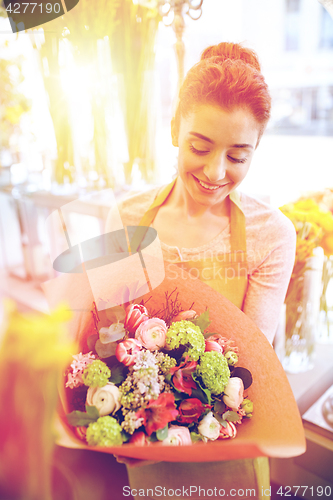 Image of smiling florist woman with bunch at flower shop