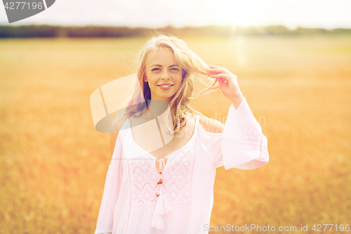 Image of smiling young woman in white dress on cereal field