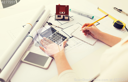 Image of close up of architect hand counting on calculator