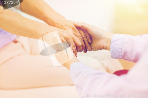 Image of close up of senior and young woman hands