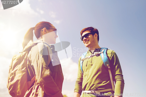 Image of happy couple with backpacks hiking outdoors