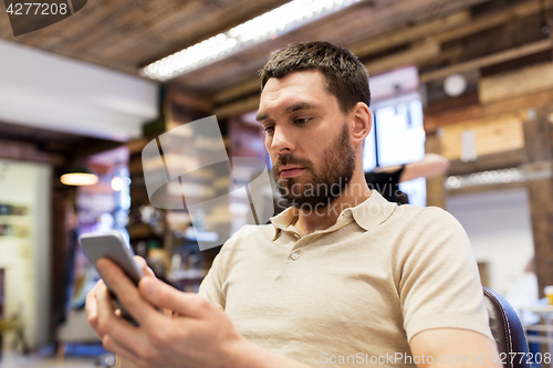 Image of man with smartphone at barbershop or salon