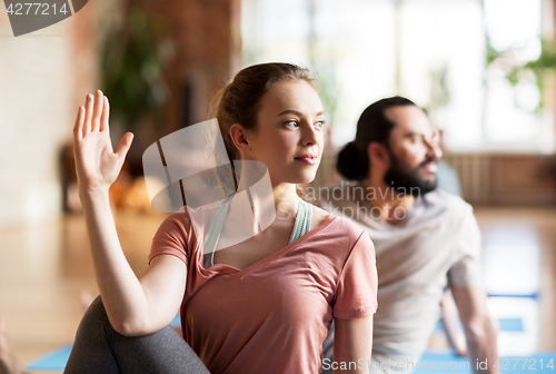 Image of woman with group of people doing yoga at studio