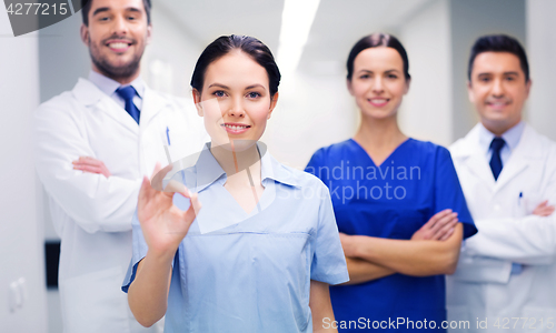 Image of group of medics at hospital showing ok hand sign