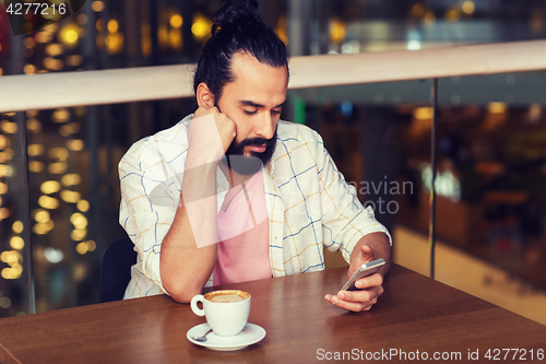 Image of man with smartphone and coffee at restaurant