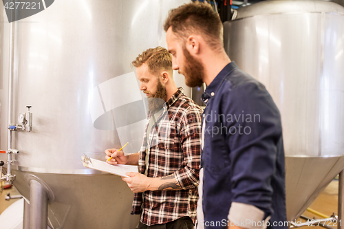 Image of men with clipboard at craft brewery or beer plant