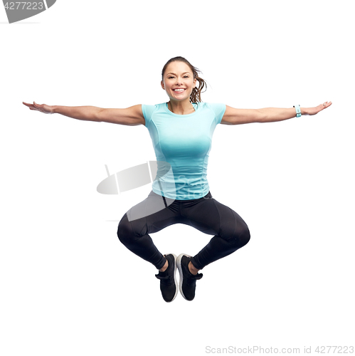 Image of happy smiling sporty young woman jumping in air